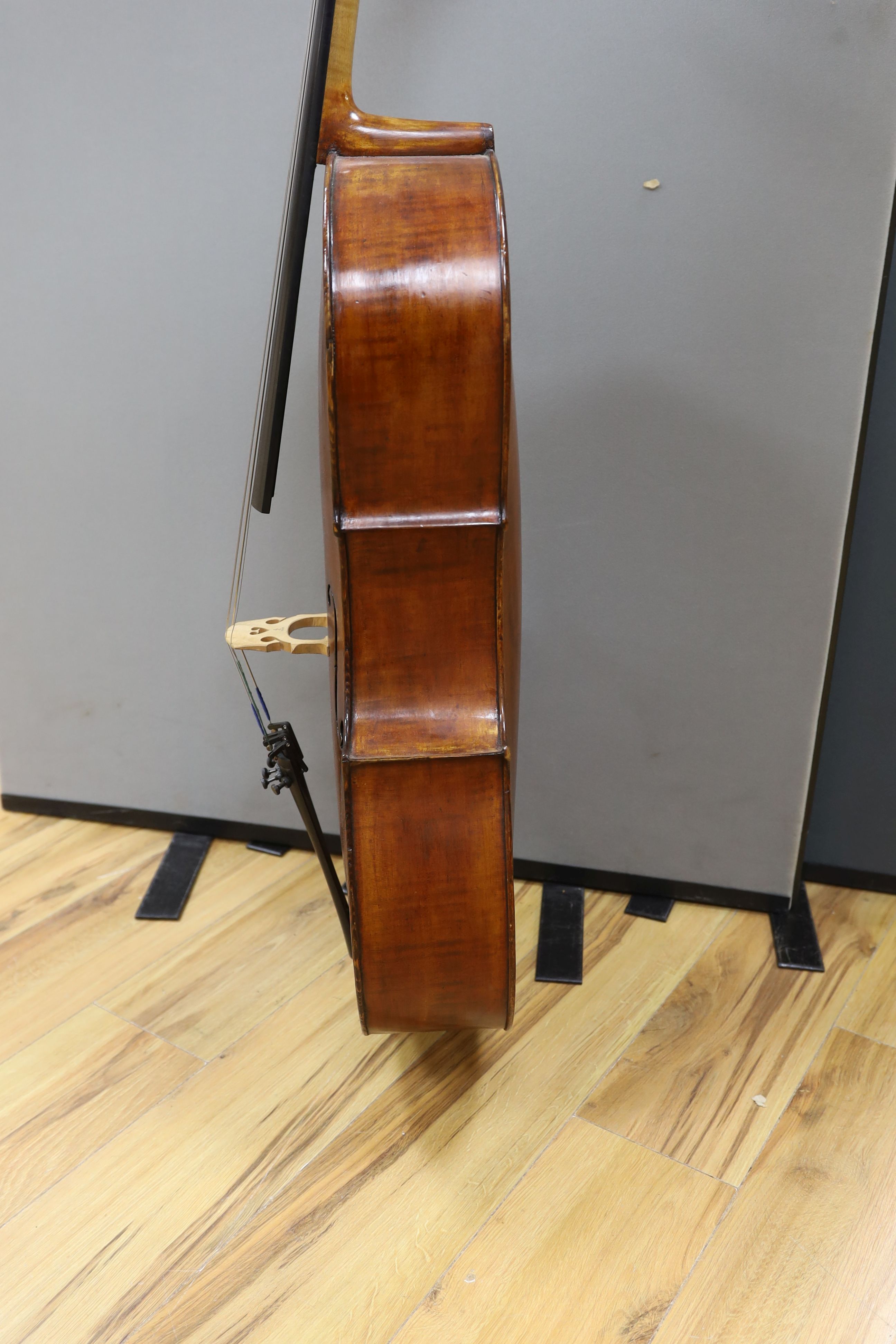A cased early 20th century ‘cello, length of body 75.5cm, with two spare bridges, and spare strings